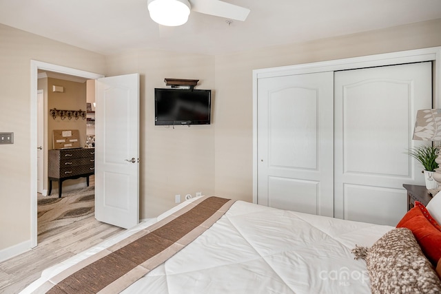 bedroom with a closet, ceiling fan, and light hardwood / wood-style flooring