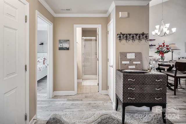 hall with a notable chandelier, light hardwood / wood-style floors, and crown molding