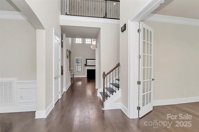 foyer featuring a high ceiling, ornamental molding, and dark hardwood / wood-style flooring