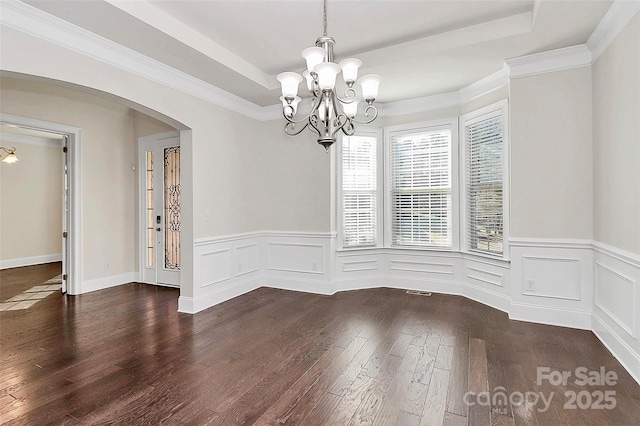 spare room with ornamental molding, dark hardwood / wood-style floors, and a chandelier