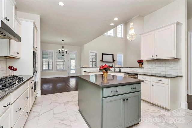 kitchen with white cabinets, backsplash, and a chandelier