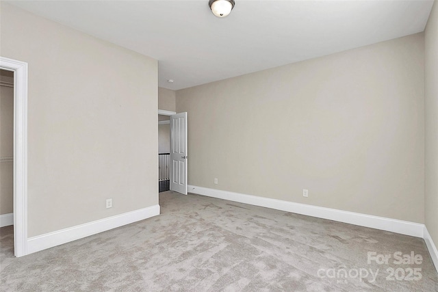 unfurnished bedroom with light colored carpet and a closet