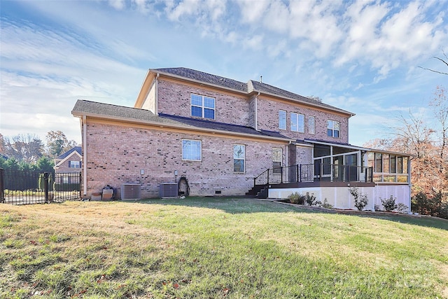 rear view of house featuring a sunroom, a yard, and central AC