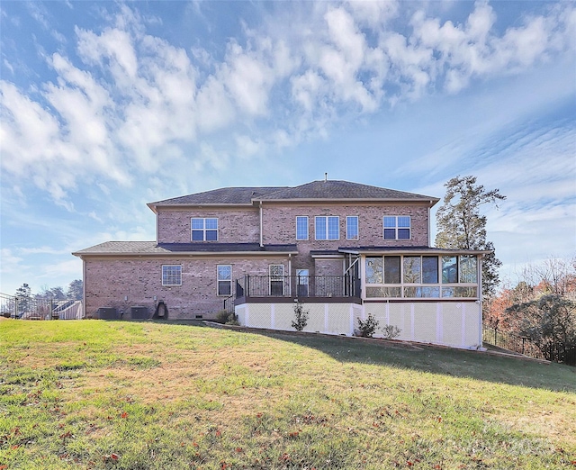 rear view of property featuring a sunroom, a yard, and cooling unit