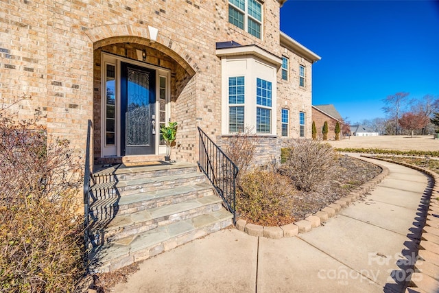 entrance to property featuring brick siding