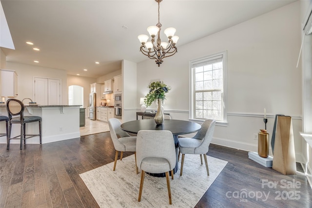 dining room with baseboards, dark wood-style flooring, a notable chandelier, and recessed lighting