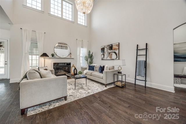 living room with plenty of natural light, a fireplace, baseboards, and wood finished floors