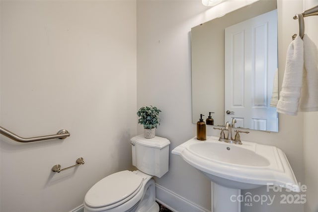 bathroom with baseboards and toilet