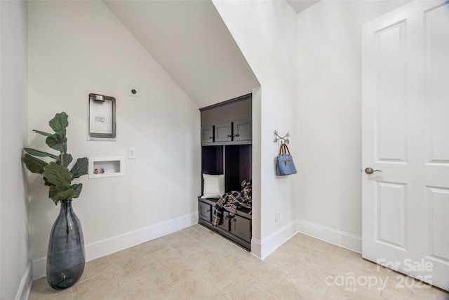 interior space featuring lofted ceiling, light tile patterned floors, and baseboards