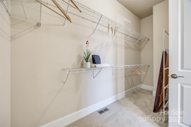 walk in closet featuring light colored carpet and visible vents