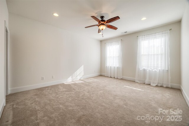 carpeted spare room featuring a ceiling fan, recessed lighting, visible vents, and baseboards