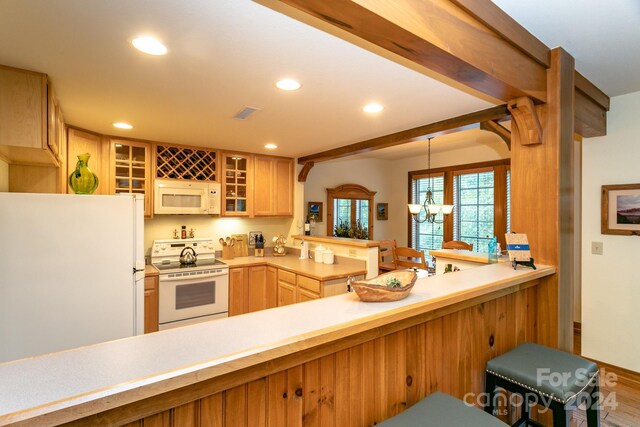 kitchen with hardwood / wood-style flooring, an inviting chandelier, decorative light fixtures, white appliances, and kitchen peninsula