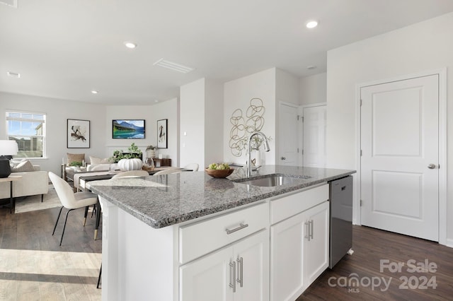 kitchen with a kitchen island with sink, dark wood-type flooring, sink, white cabinetry, and light stone countertops