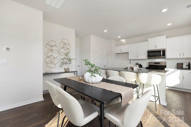 dining area with sink and dark hardwood / wood-style flooring