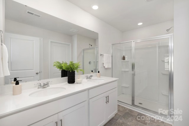 bathroom with vanity and a shower with shower door