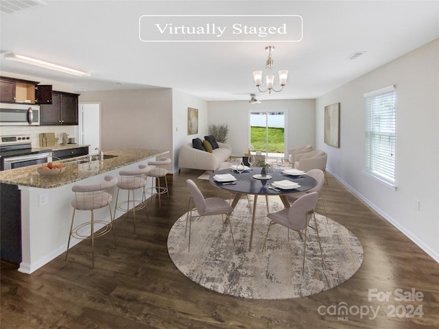 dining area featuring a chandelier, sink, and dark hardwood / wood-style floors