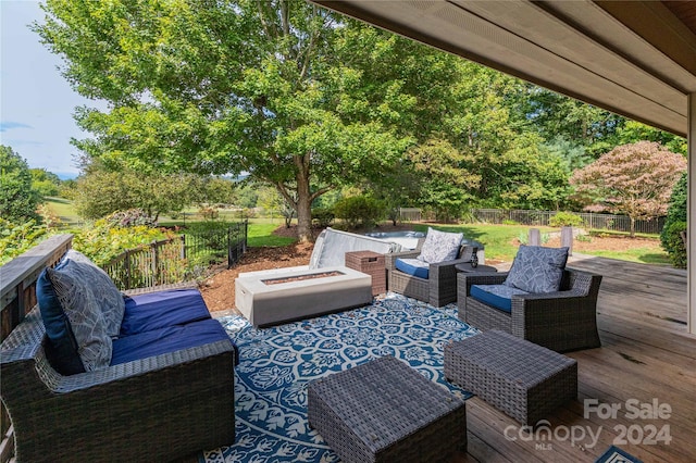 view of patio featuring a wooden deck and an outdoor living space with a fire pit