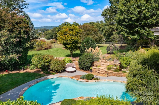 view of swimming pool featuring a lawn