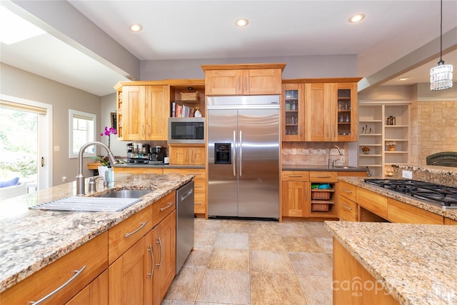 kitchen with built in appliances, decorative light fixtures, backsplash, sink, and light stone counters