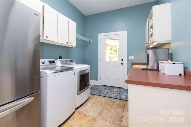 laundry area with light tile patterned floors, cabinets, and independent washer and dryer