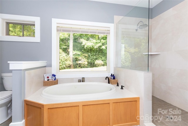 bathroom featuring separate shower and tub, toilet, and plenty of natural light