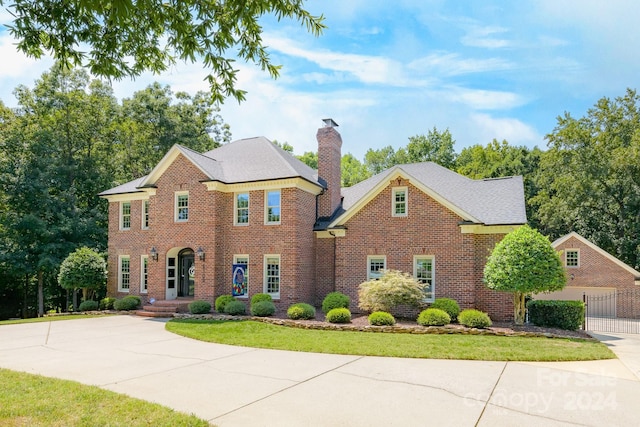 view of front facade with brick siding and a chimney