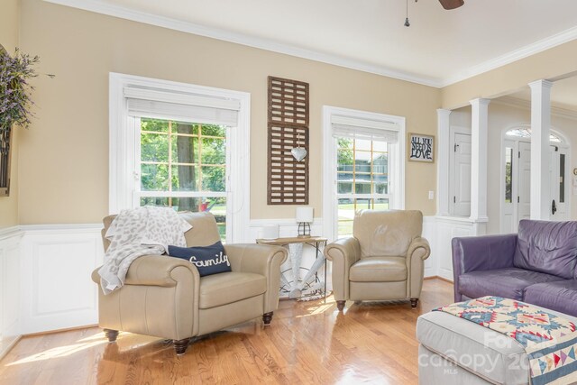 living room featuring decorative columns, ornamental molding, a wealth of natural light, and ceiling fan