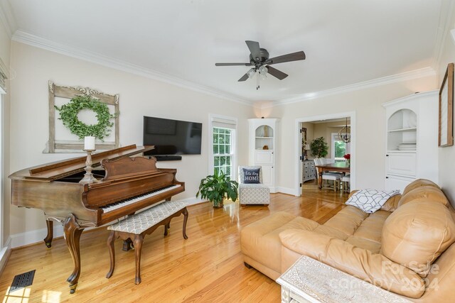 living room featuring crown molding, light hardwood / wood-style flooring, and ceiling fan