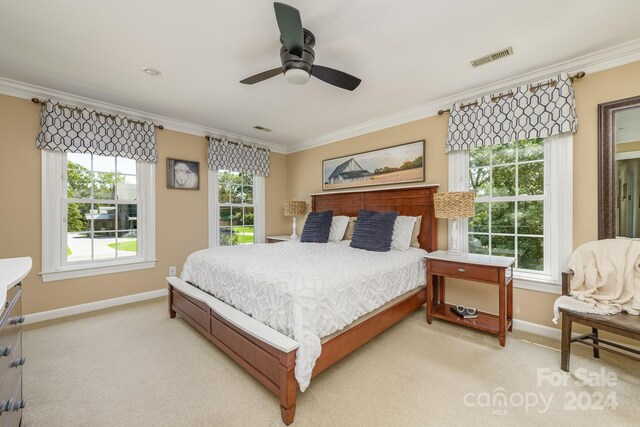 carpeted bedroom with ceiling fan and ornamental molding