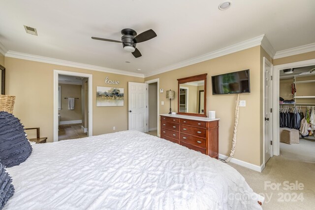 carpeted bedroom with a closet, ceiling fan, and crown molding