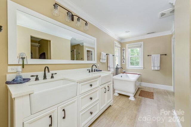 bathroom featuring crown molding, a tub, and vanity