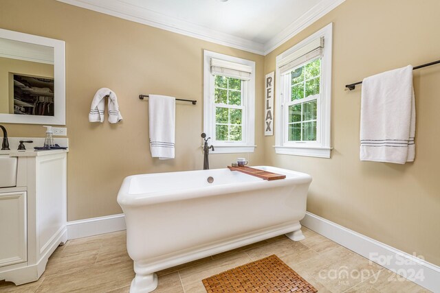 bathroom featuring a tub to relax in, vanity, tile patterned floors, and crown molding