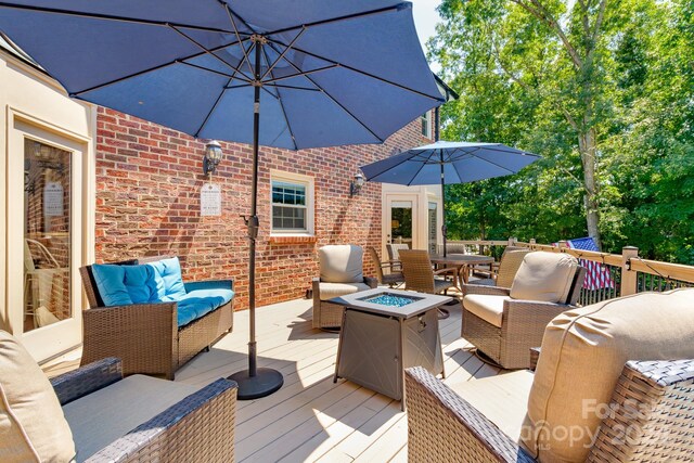 deck featuring an outdoor living space with a fire pit