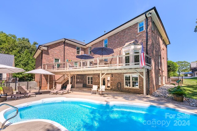 back of house with a fenced in pool and a patio area