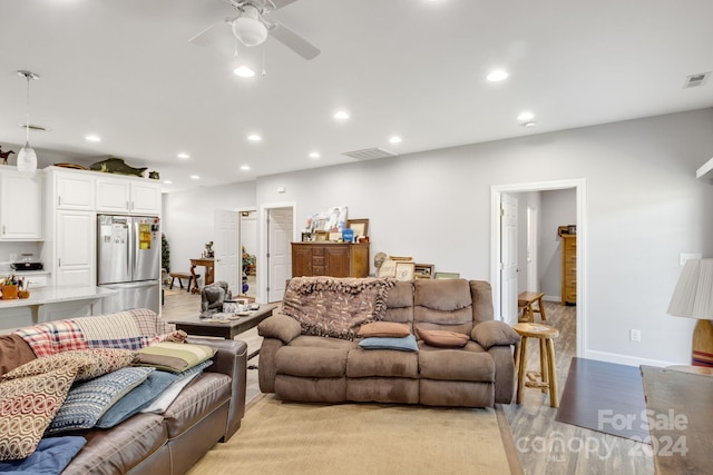 living room with light hardwood / wood-style flooring and ceiling fan