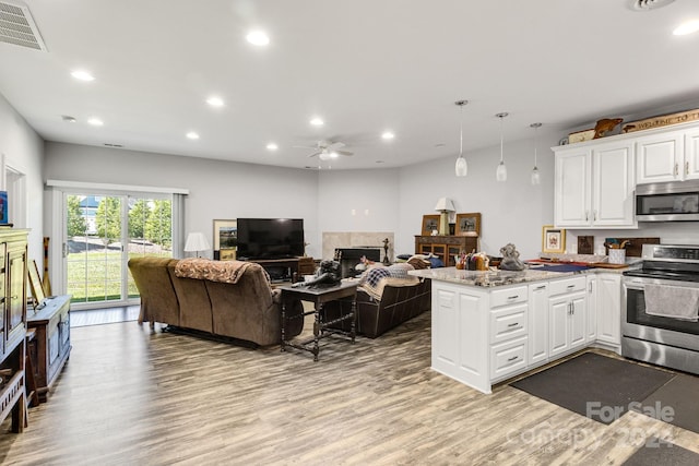 kitchen featuring light stone counters, ceiling fan, appliances with stainless steel finishes, hardwood / wood-style flooring, and white cabinets