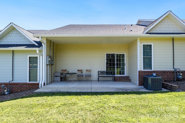 back of house with central AC, a yard, and a patio area