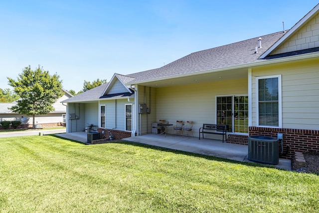 rear view of house featuring a lawn, a patio area, and central air condition unit