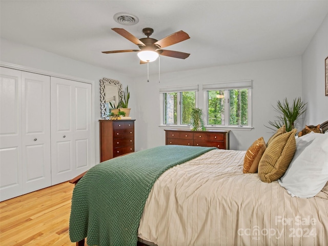 bedroom featuring light hardwood / wood-style flooring, ceiling fan, and a closet