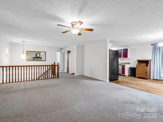 interior space with light carpet, a textured ceiling, and ceiling fan