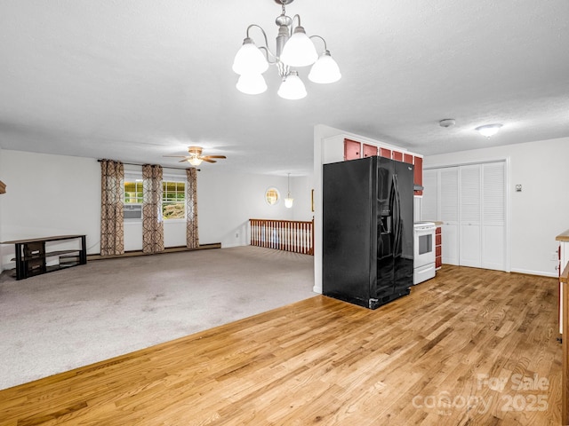 kitchen with black refrigerator with ice dispenser, ceiling fan with notable chandelier, white electric stove, a textured ceiling, and light colored carpet