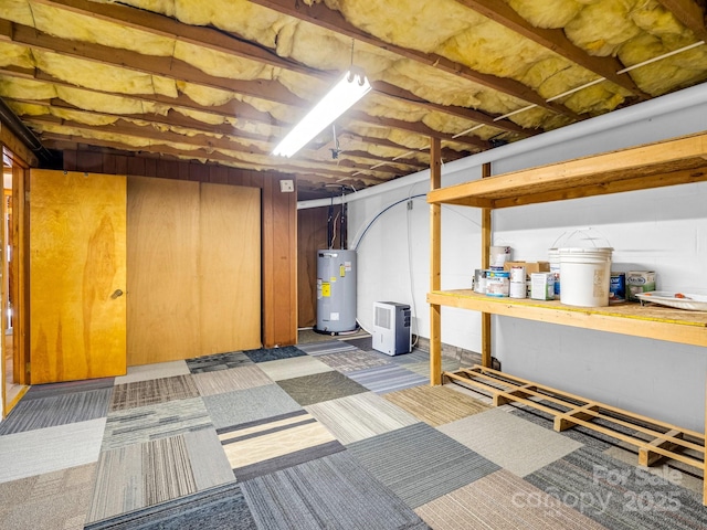 basement featuring dark colored carpet and electric water heater