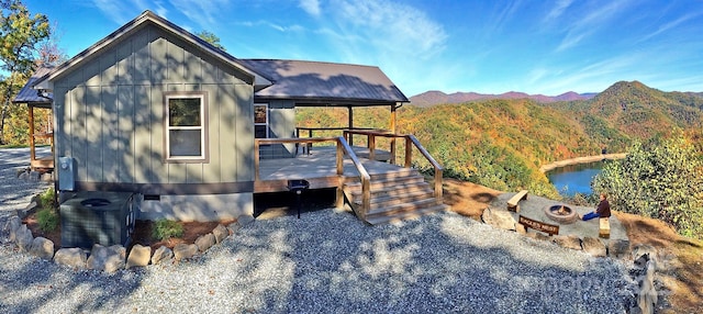 view of front of home with an outdoor fire pit and a deck with mountain view