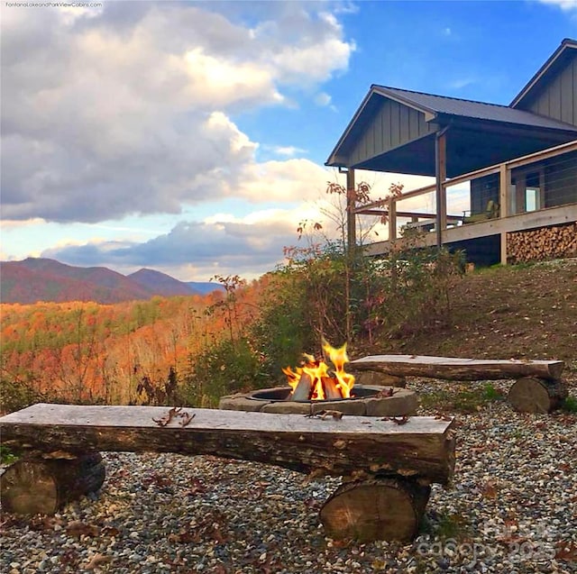 view of yard featuring a mountain view and an outdoor fire pit