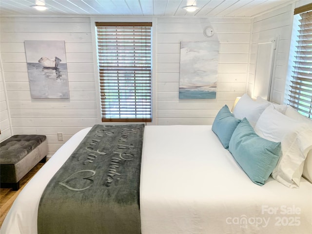 bedroom with wood ceiling and wooden walls