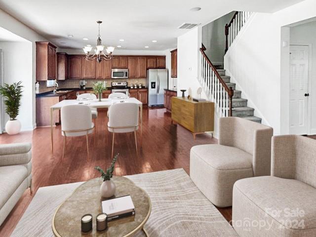 living room with a notable chandelier and dark hardwood / wood-style floors