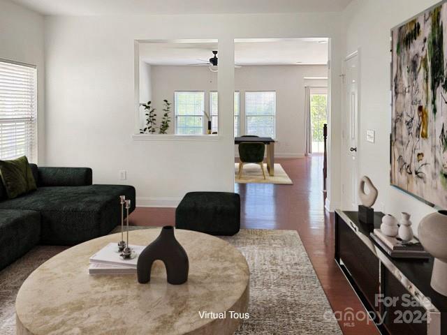 living room featuring ceiling fan and dark wood-type flooring