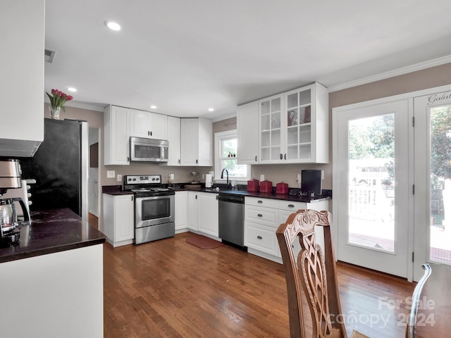 kitchen with a healthy amount of sunlight, stainless steel appliances, dark hardwood / wood-style floors, and white cabinets