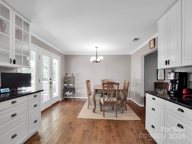 kitchen with white cabinets, french doors, dark hardwood / wood-style floors, pendant lighting, and ornamental molding