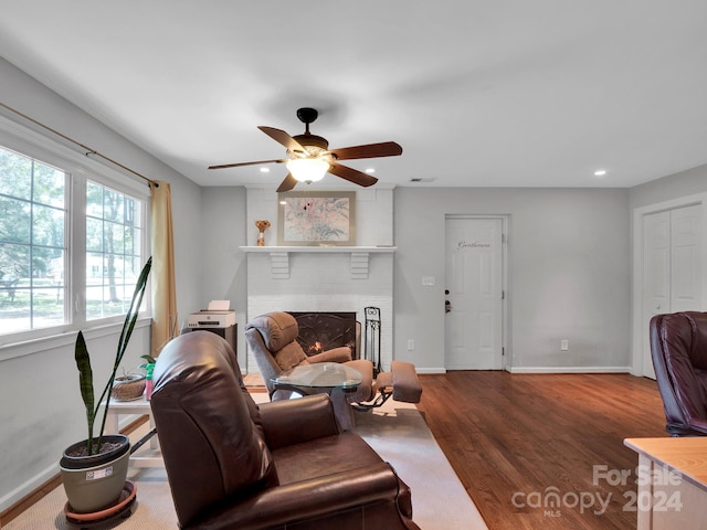 living room with ceiling fan, dark hardwood / wood-style flooring, and a fireplace